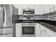 Kitchen featuring modern stainless steel appliances, countertops, and white cabinets at 2208 Orkney Dr, Leesburg, FL 34788