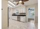 Charming kitchen featuring white cabinets, stainless steel appliances, and tile flooring at 2208 Orkney Dr, Leesburg, FL 34788