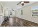 Bright living room features wood floors, ceiling fans, and multiple windows at 2208 Orkney Dr, Leesburg, FL 34788