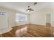 Bright living room with hardwood floors, ceiling fan, and ample natural light at 2208 Orkney Dr, Leesburg, FL 34788