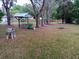 Large backyard featuring mature trees and swings providing lots of outdoor space at 22736 Sw 117Th St, Dunnellon, FL 34431