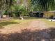 Spacious backyard featuring a lush lawn, mature trees, and a swing set for outdoor enjoyment at 22736 Sw 117Th St, Dunnellon, FL 34431