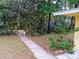 Secluded backyard pathway leading to a private garden oasis surrounded by mature trees and lush greenery at 22736 Sw 117Th St, Dunnellon, FL 34431