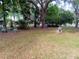 Landscaped backyard featuring mature trees and decorative accents, creating a tranquil outdoor space at 22736 Sw 117Th St, Dunnellon, FL 34431