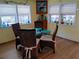 Cozy dining area featuring a glass table with four cushioned chairs, complemented by natural light from the windows at 22736 Sw 117Th St, Dunnellon, FL 34431