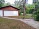 Detached two-car garage surrounded by lush greenery and mature trees, offering ample space for parking and storage at 22736 Sw 117Th St, Dunnellon, FL 34431