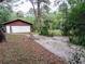 Detached two-car garage with a driveway and surrounded by mature trees, providing ample parking and storage at 22736 Sw 117Th St, Dunnellon, FL 34431