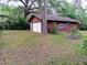 Detached two-car garage with surrounded by grass and mature trees, offering ample space for parking and storage at 22736 Sw 117Th St, Dunnellon, FL 34431
