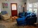 Cozy living room with a plush blue sofa, wooden door and a bright airy space at 22736 Sw 117Th St, Dunnellon, FL 34431