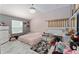 Bedroom features a bed, dresser, and a large window for natural light at 2296 Sheehan St, The Villages, FL 32163