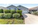 Charming single-story home with a two-car garage, lush landscaping, and a concrete driveway in daytime at 2296 Sheehan St, The Villages, FL 32163