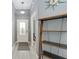 Foyer with light gray flooring leads to other rooms, shelf to the side and front door in view at 2296 Sheehan St, The Villages, FL 32163