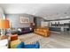 Open-concept living room featuring laminate flooring, gray walls, sofas, and a view of the kitchen bar at 2296 Sheehan St, The Villages, FL 32163
