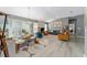 Bright living room with vaulted ceiling, ceiling fan, gray walls, laminate flooring, and sliding glass doors at 2296 Sheehan St, The Villages, FL 32163