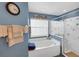 Bright bathroom featuring a soaking tub, glass-enclosed shower, and a large window at 2434 Walnut Heights Rd, Apopka, FL 32703