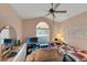 Bedroom with a cozy quilt, mirror, TV, and abundant natural light at 2434 Walnut Heights Rd, Apopka, FL 32703