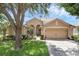 Charming single-story home with a well-manicured lawn, lush landscaping and a 2 car garage at 2434 Walnut Heights Rd, Apopka, FL 32703