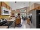 Well-lit kitchen with stainless steel appliances and a view of the living and dining spaces at 2434 Walnut Heights Rd, Apopka, FL 32703