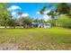 Expansive green backyard with a white home, complemented by a screened-in porch and mature trees at 2475 Sw 7Th Ave, Ocala, FL 34471