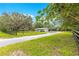 Residential home with a long driveway, expansive lawn, garage, and screened-in porch, surrounded by mature trees at 2475 Sw 7Th Ave, Ocala, FL 34471