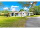 Single-story home featuring turquoise shutters and a door, complemented by a lush green lawn and paved driveway at 2475 Sw 7Th Ave, Ocala, FL 34471