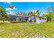 The rear of a home featuring a screened-in porch, a white exterior, and a well-maintained lawn at 2475 Sw 7Th Ave, Ocala, FL 34471