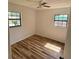 Bedroom with laminate floors, two windows, and natural light at 3740 Ne 5Th St, Ocala, FL 34470