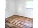 Bedroom showcasing new wood floors, white walls, and natural light from the windows at 3740 Ne 5Th St, Ocala, FL 34470