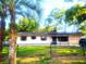 Charming single-story home with a well-maintained lawn and a black chain-link fence at 3740 Ne 5Th St, Ocala, FL 34470