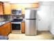 Kitchen with stainless steel appliances and wood cabinets and tiled backsplash at 3740 Ne 5Th St, Ocala, FL 34470