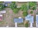 Aerial shot of the house showing the roof, driveway, and surrounding lot with greenery and nearby buildings at 4331 Se 106Th Pl, Belleview, FL 34420
