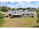 Expansive backyard with a well-maintained lawn, mature trees, and a screened porch attached to the rear of the house at 4331 Se 106Th Pl, Belleview, FL 34420