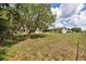Large backyard with a spacious lawn, mature trees, and a partial view of the rear of the house at 4331 Se 106Th Pl, Belleview, FL 34420