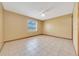 Sunny bedroom featuring neutral walls, tiled floor, a ceiling fan, and a window at 4331 Se 106Th Pl, Belleview, FL 34420