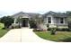 Charming single-story home featuring a well-manicured lawn, lush landscaping, and a paved driveway leading to the front entrance at 4990 Sw 63Rd Loop, Ocala, FL 34474