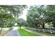 Tree-lined street in a residential area with sidewalks and white picket fences at 4990 Sw 63Rd Loop, Ocala, FL 34474