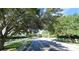 A street with white picket fences on either side, shaded by mature trees at 4990 Sw 63Rd Loop, Ocala, FL 34474