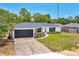 Charming single story home with a well-maintained lawn, modern black garage door and stone accents at 6 Bahia Circle Loop, Ocala, FL 34472