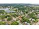 Aerial view of a home nestled in a mature neighborhood with a pond nearby at 705 Washington Ave, Eustis, FL 32726