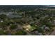 Aerial view showcasing the home's location nestled amongst lush trees and a nearby lake at 705 Washington Ave, Eustis, FL 32726