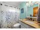 Bathroom featuring a vanity with granite countertop and a shower with a floral shower curtain at 705 Washington Ave, Eustis, FL 32726