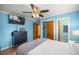 Bedroom with hardwood floors and blue walls, showcasing closet space and wood doors at 705 Washington Ave, Eustis, FL 32726