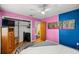 Bedroom showcasing a wood dresser, hardwood floors, and pink and blue accent wall at 705 Washington Ave, Eustis, FL 32726