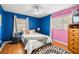 Bright bedroom with hardwood floors, ceiling fan, and light blue accent wall at 705 Washington Ave, Eustis, FL 32726