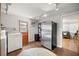 Convenient laundry room with stainless steel refrigerator and access to an additional room and exterior door at 705 Washington Ave, Eustis, FL 32726