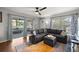 Comfortable living room with large couch, exterior door to porch, ceiling fan, and hardwood floors at 705 Washington Ave, Eustis, FL 32726