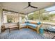 Inviting screened porch with stylish seating, ceiling fan, and blue patterned rug at 705 Washington Ave, Eustis, FL 32726