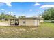 Exterior shot of house highlighting its backyard and attached carport at 705 Washington Ave, Eustis, FL 32726