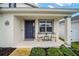 Inviting front porch featuring comfortable seating, a charming accent table, and a welcoming entrance at 7224 Sw 61St Pl, Ocala, FL 34474