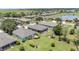 Aerial view of a residential neighborhood showcasing well-manicured lawns, mature trees, and a serene pond at 7333 Sw 98Th Ct, Ocala, FL 34481